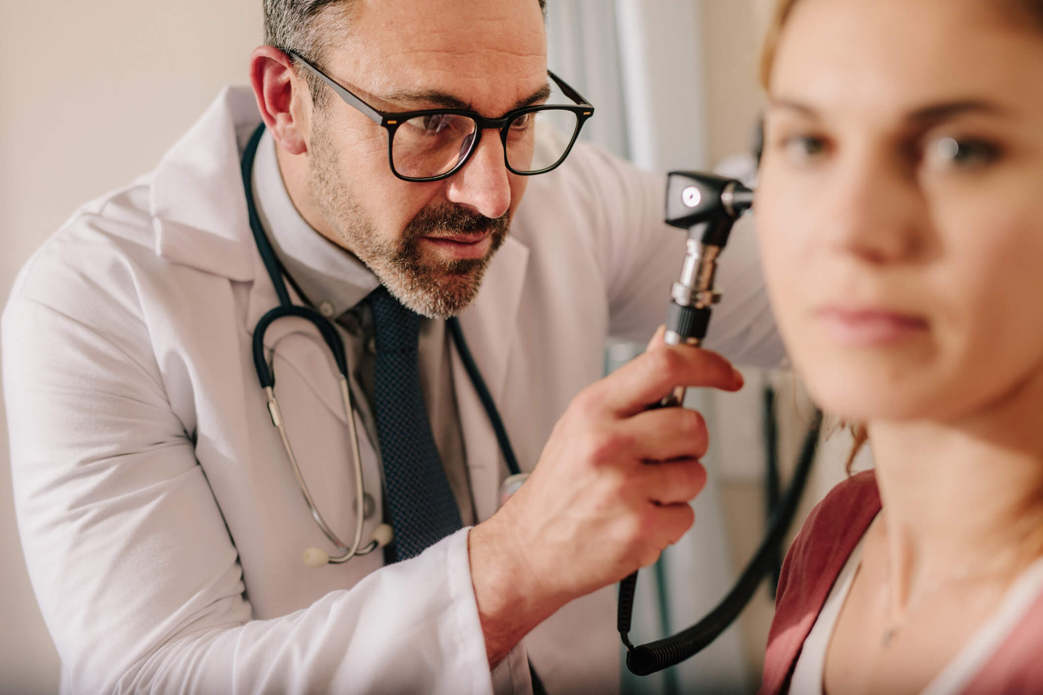 Doctor using a otoscope to look in a patient's ear